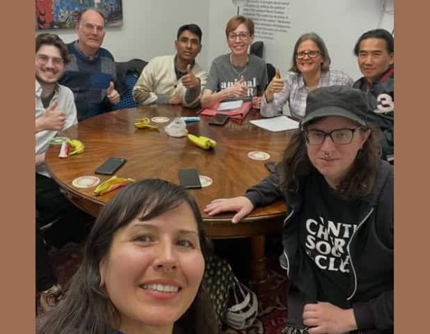 Group of diverse individuals gathered around a table at an Animal Rights Toronto meeting, engaging in discussion and activism for animal welfare.