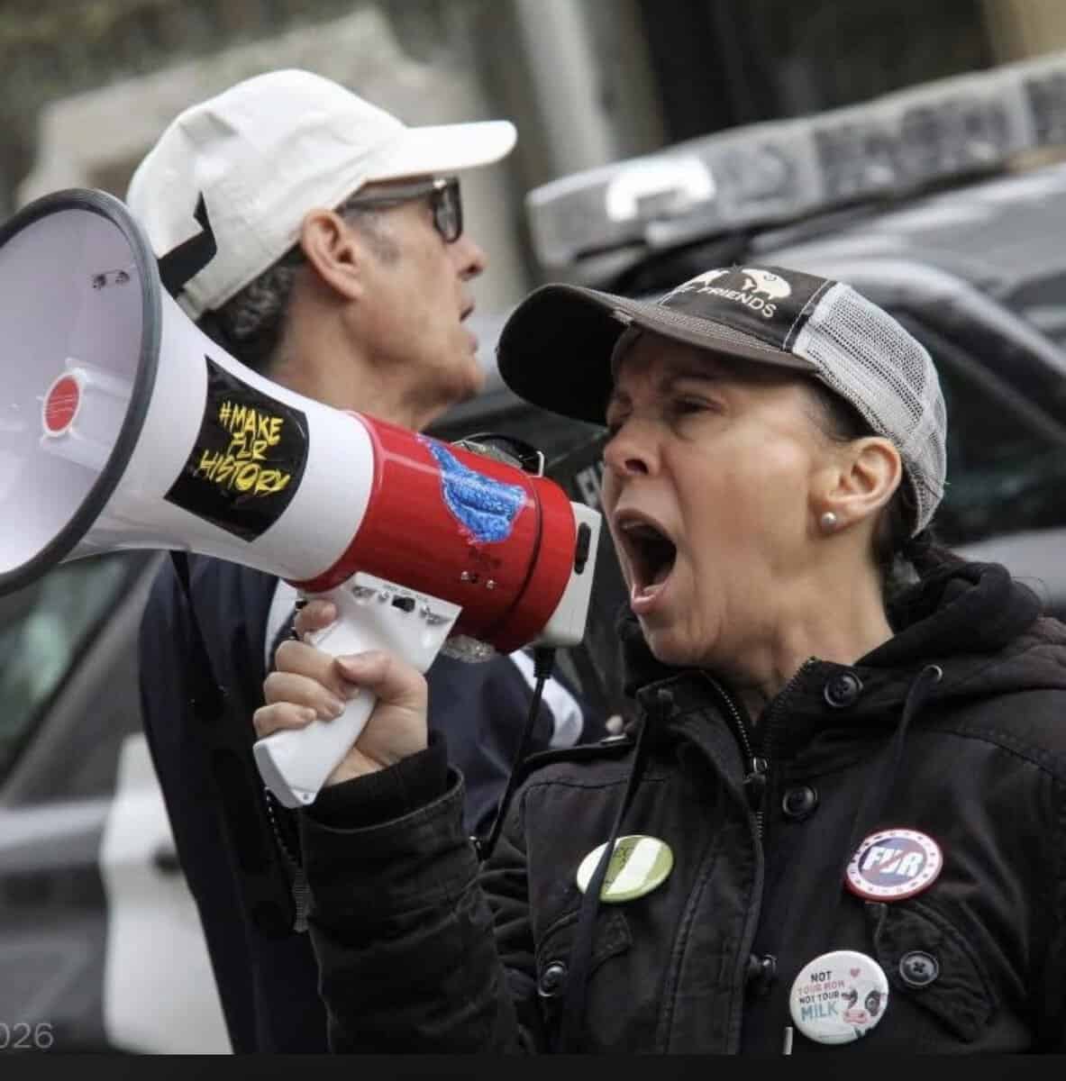 Protesters at FurFree Toronto event using a megaphone to advocate for animal rights and oppose fur industry practices.